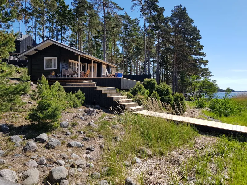 Musta laudisega rannamaja terrassi ja laudteega mererannas