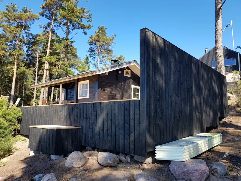 Musta laudisega maja uus tuulevarjusein ja varjualune